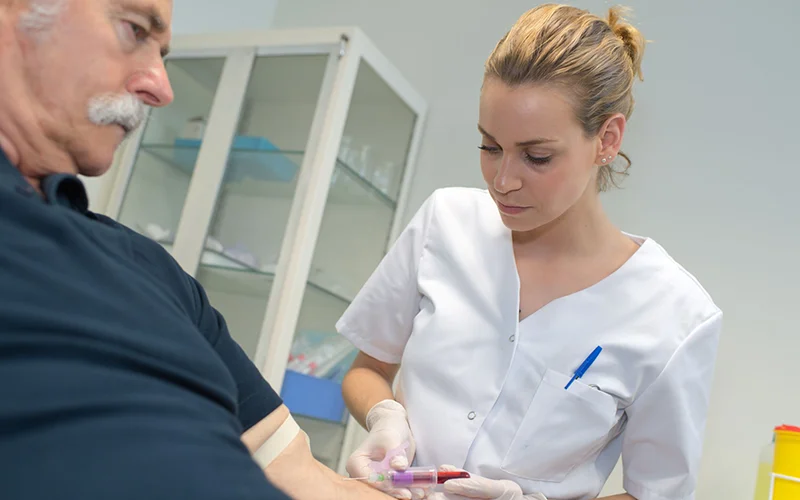 dementia nurse takes blood sample from an older man